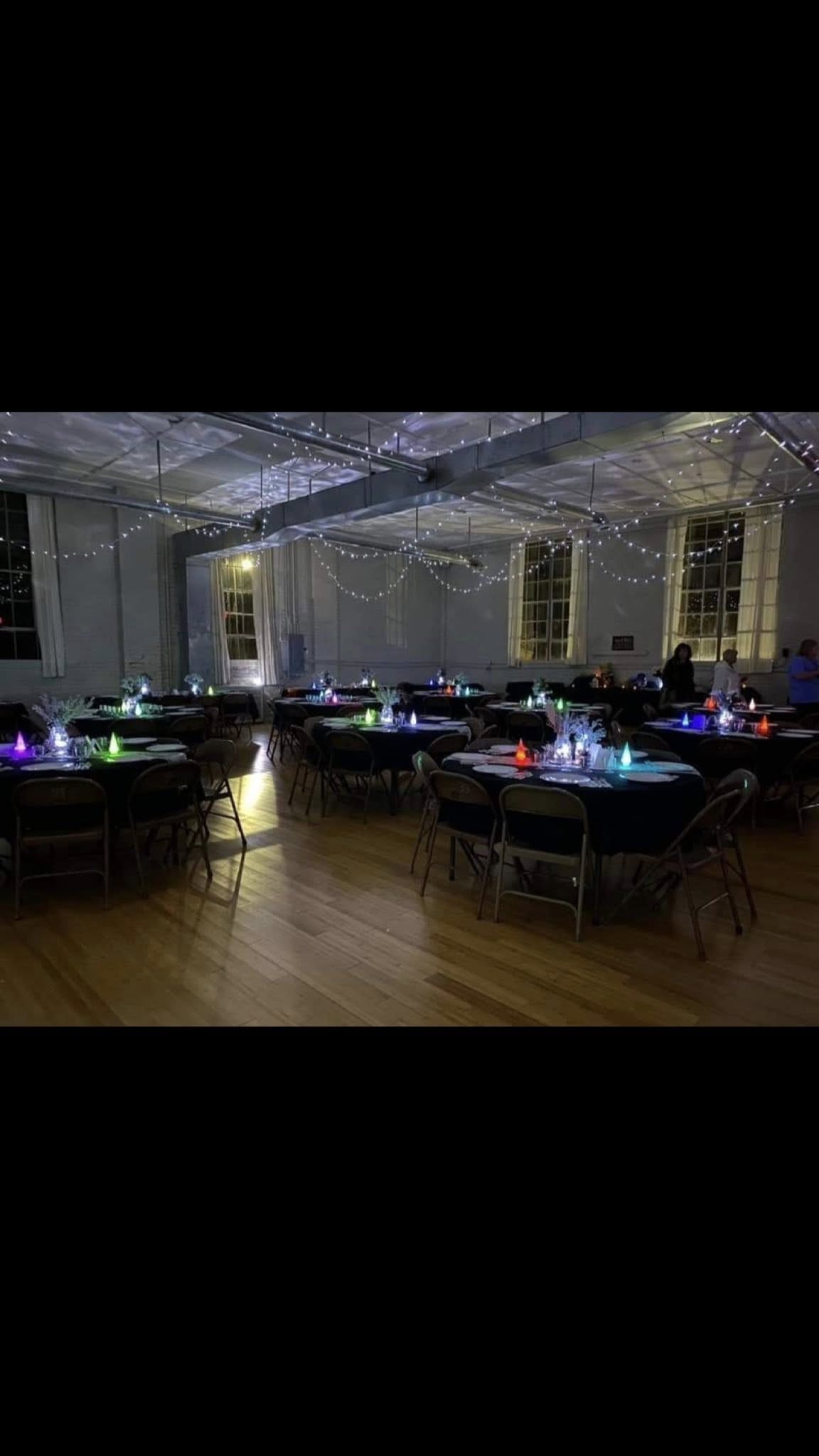 Set up for a community event — tables, lights, and a full house